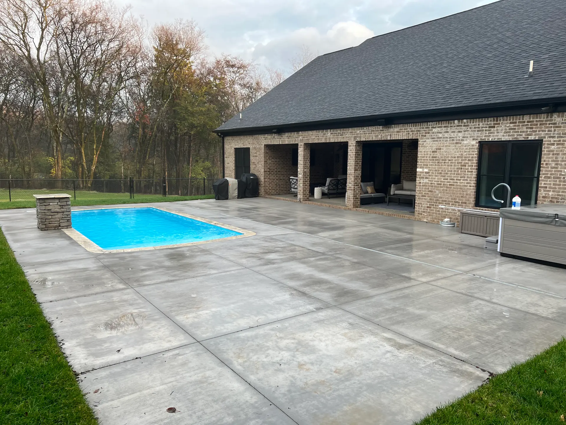 Large multi-panel concrete patio with integrated fiberglass pool